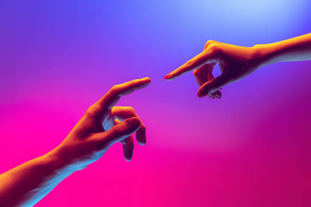 istock Two human hands trying to touch each other isolated on gradient blue-pink background in neon light. Concept of human relation, togetherness, symbolism, culture and history 1395134869