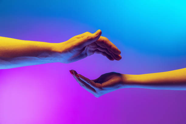 istock Two authentic hands trying to touch each other isolated on gradient blue purple background in neon light. Concept of relationship, community, care, support, symbolism, culture 1395134909
