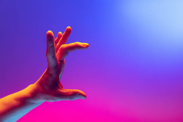 istock Human hand gesturing isolated on gradient purple-pink background in neon light. Concept of sign language, creativity, symbolism, culture and art 1395135097