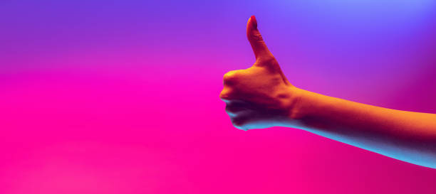 istock Human hand gesturing isolated on gradient purple-pink background in neon light. Concept of sign language, creativity, symbolism, culture and art 1395136596