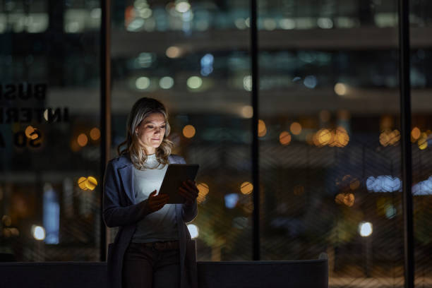 istock Young businesswoman using touchpad late in the office. 1395136881