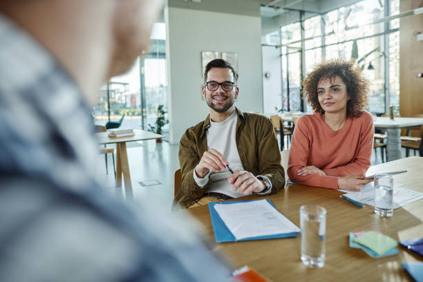 istock Happy creative colleagues talking on a meeting in modern office. 1395136910