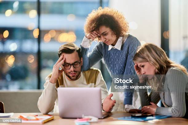Worried Creative Team Working On Laptop In The Office Stock Photo - Download Image Now
