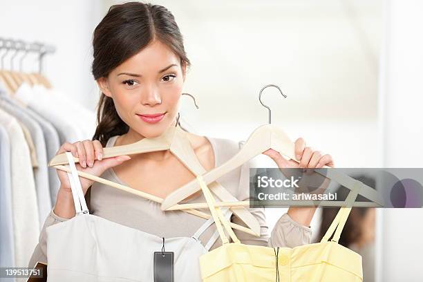 Mujer Tratando De Ropa Foto de stock y más banco de imágenes de 20 a 29 años - 20 a 29 años, A la moda, Actividad comercial