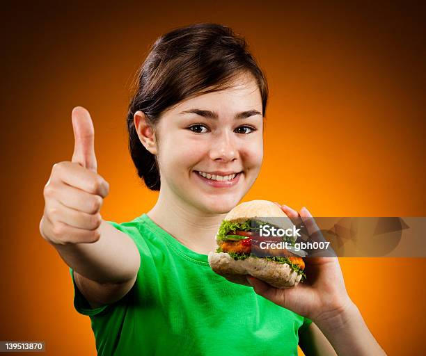 Mädchen Essen Hamburger Zeigen Okzeichen Stockfoto und mehr Bilder von 14-15 Jahre - 14-15 Jahre, Blick in die Kamera, Burger