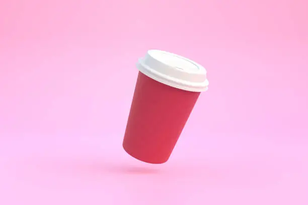 Photo of Disposable paper coffee cup with black lid in the air over pink background