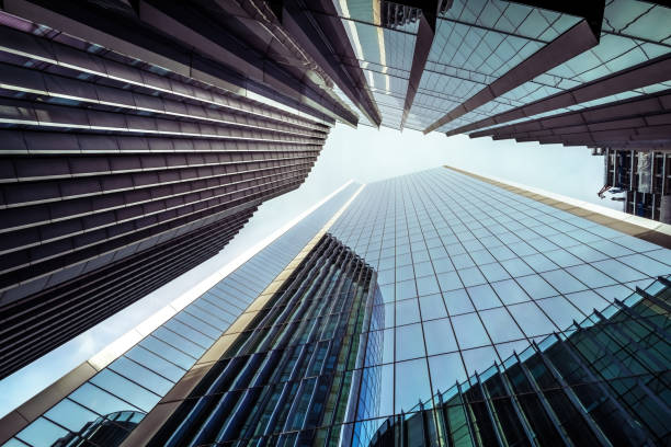 istock Looking up at modern architecture to the sky. Windows and reflections on a clear day in London 1395139866
