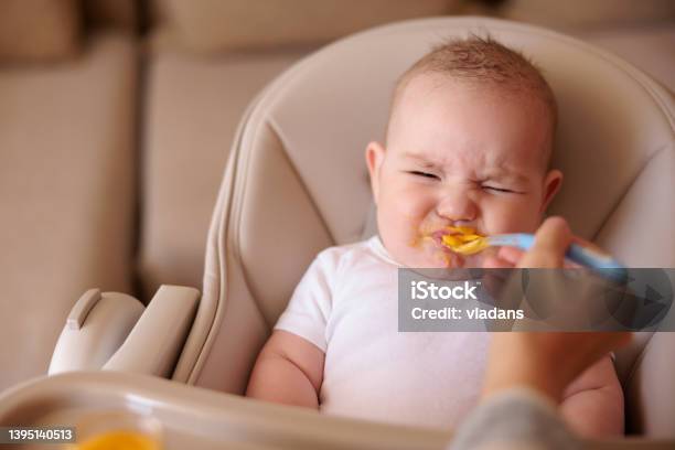 Baby Making Funny Faces While Refusing To Eat Porridge Stock Photo - Download Image Now
