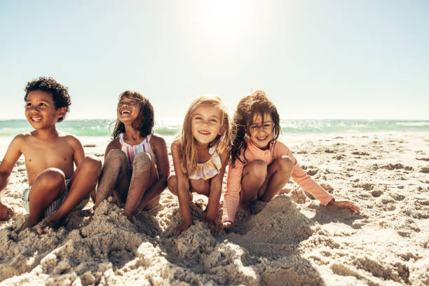 istock Happy young children playing with beach sand 1395144462