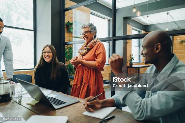 Diverse Businesspeople Smiling Cheerfully During An Office Meeting Stock Photo - Download Image Now
