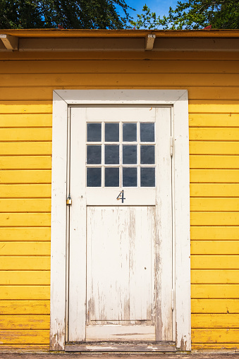 White wooden door on a yellow beach hut