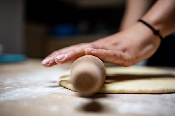istock Hands baking dough with rolling pin on wooden table 1395150480