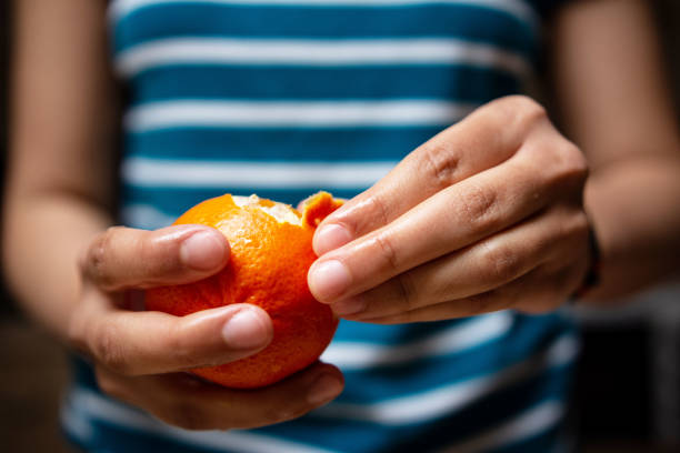 Close-up of female hands preparing fruits for natural juice