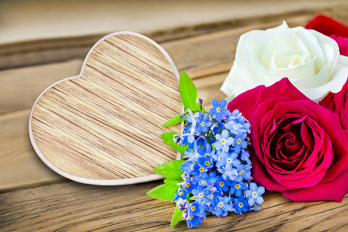Heart and flowers on wooden background