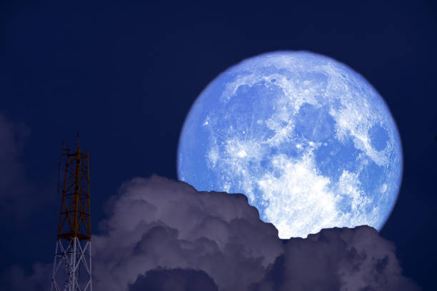 istock Full Snow Moon on night sky back cloud silhouette signal pole 1395152203