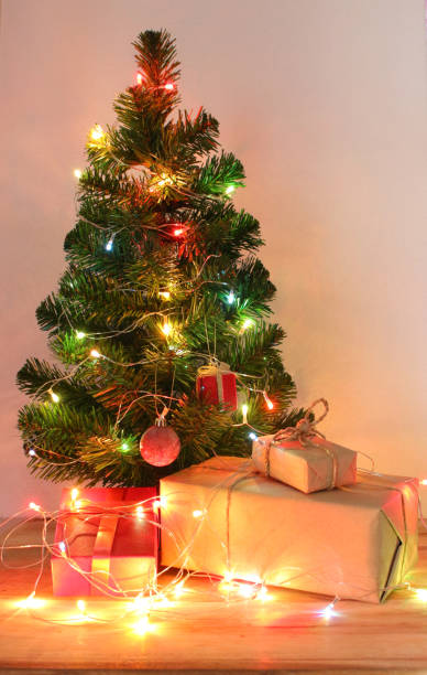 istock light celebration on christmas tree with gift box in living room 1395152260