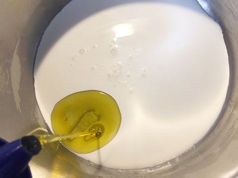 Preparing food with cream and olive oil in the cooking pan