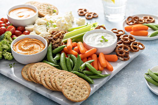 Plant based snack board with vegetables, crackers and dairy free dips