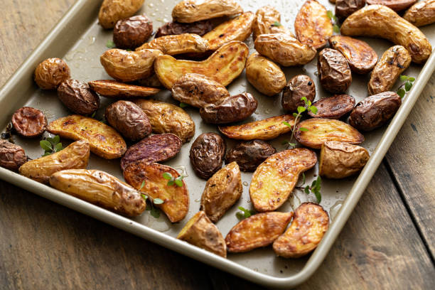 roasted crispy fingerling potatoes on a sheet pan - fingerling imagens e fotografias de stock