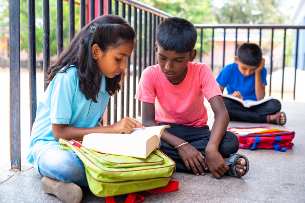 focus on boy Teenage kids busy studying or preparing before examination while sitting on school corridor - concept of education,childhood development and learning