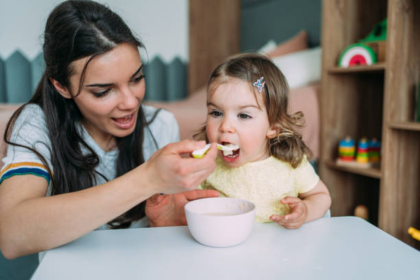 istock Mother feeding her cute little daughter. 1395154809