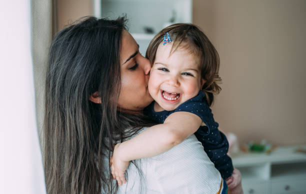istock Affectionate mother and daughter embracing at home. 1395154818