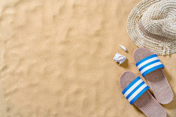 istock Vacations background: sandals and sunhat on sand background 1395155933