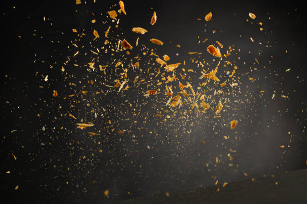 istock Crumb explosion, flying bread ot pastry crumbs isolated on black background 1395156500