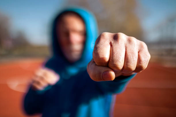 Senior fighter shadow boxing outdoors ,focus on fist Senior boxer fighter shadow boxing outdoors on a sunny day old man boxing stock pictures, royalty-free photos & images