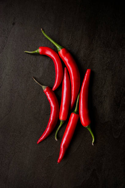 istock Top view of red chilli pods on a wood table 1395157264