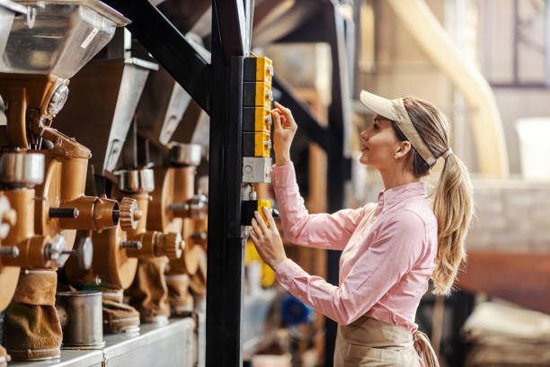 istock A female operator starting coffee grinding machine in factory. 1395158373