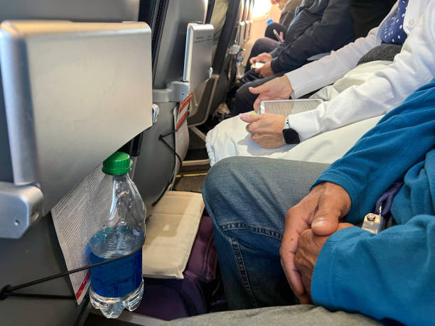 Cramped people on an airplane Passengers on an airline carrier are sitting very close together with very little leg room economy class stock pictures, royalty-free photos & images