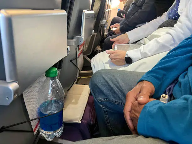 Passengers on an airline carrier are sitting very close together with very little leg room