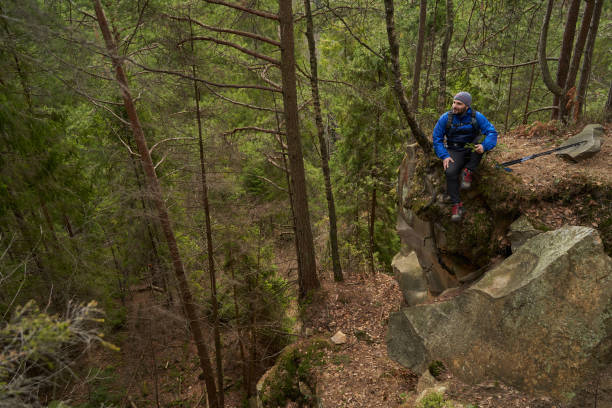 istock Male trekker sitting on forest crag during rest stop 1395161016