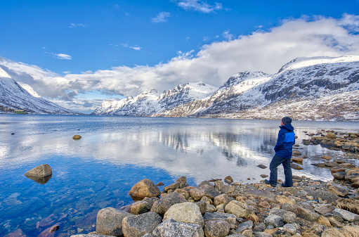 Hiker enjoying the beautiful fjord of Ersfjordbotn, located just west of Tromso, Norway in Northern Norway.