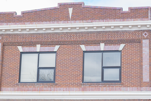 Exterior view of top floor of very old red brick building in small town in Montana in western United States of America (USA).