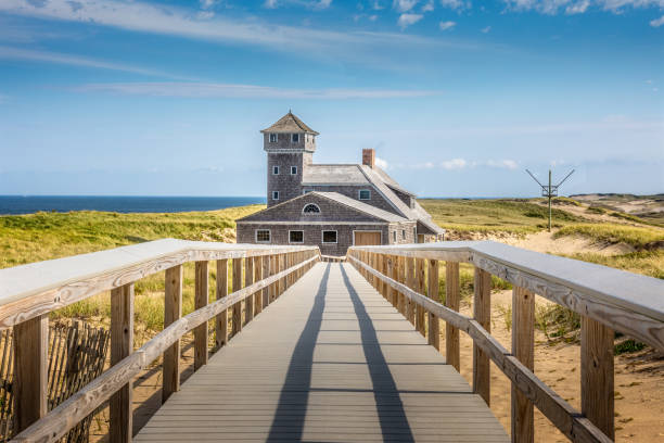 Blue sky and a boardwalk in front of the life saving building in Provincetown stock photo
