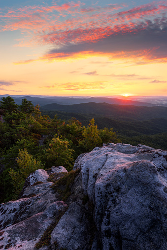 A colorful sunset over a craggy  mountain peak in the Blue Ridge Mountains of North Carolina