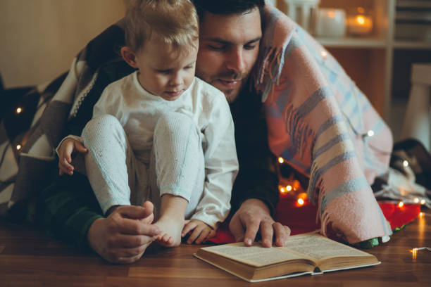 istock Young father reading book to his little daughter. 1395169023