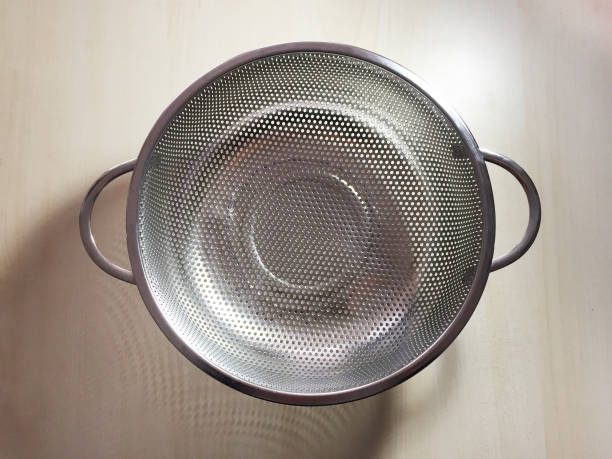 Stainless steel colander on the wood table stock photo