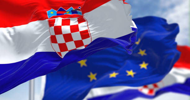 detail der nationalflagge kroatiens, die an einem klaren tag im wind weht, mit verschwommener eu-flagge im hintergrund. - croatian culture stock-fotos und bilder