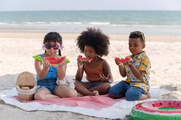 istock Happy kids eat watermelon on the beach 1395171217