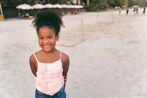 Happy afro hair kid girl on the beach