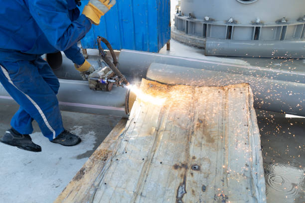 One man operates the machine to cut steel plates on the construction site