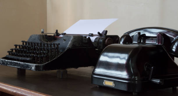 istock An old telephone with an inductor dial and a vintage typewriter on the table. 1395174077