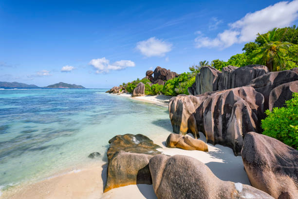 Beautiful tropical beach Anse Source d´Argent with sculpted granite rocks and palm trees - Island of La Digue, Seychelles, Indian Ocean Islands. Seychelles is the most beautiful tropical islands of the world's in the Indian Ocean. The Anse Source d'Argent is a dream beach as it is in the book and the breathtaking scenery a highlight. The mix of shallow, turquoise blue sea, white sandy beach and impressive granite cliffs make it one of the most photogenic beaches in the Seychelles. La Digue is the third most populated island of the Seychelles, and fifth largest by land area, lying east of Praslin and west of Felicite Island. In terms of size it is the fourth largest granitic island of Seychelles after Mahé, Praslin and Silhouette Island. la digue island photos stock pictures, royalty-free photos & images