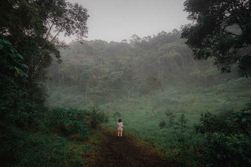 Young Caucasian woman  hiking  in the jungles in fog
