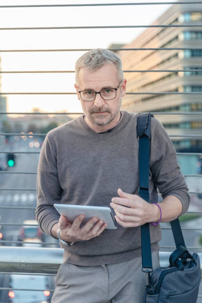 istock Business mature man using digital tablet outdoors 1395174267