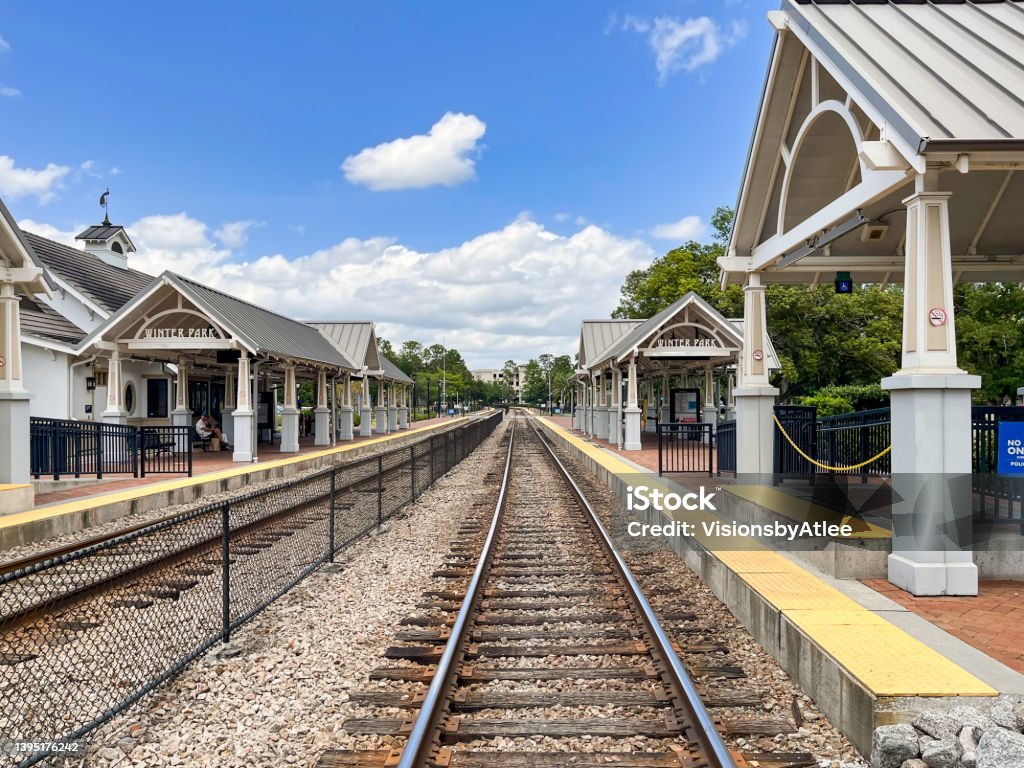 These commuter rail station platforms, which also serve interstate rail travelers, are located on a double tracked rail line next to a beautiful urban park in Winter Park, Florida. Florida - US State Stock Photo