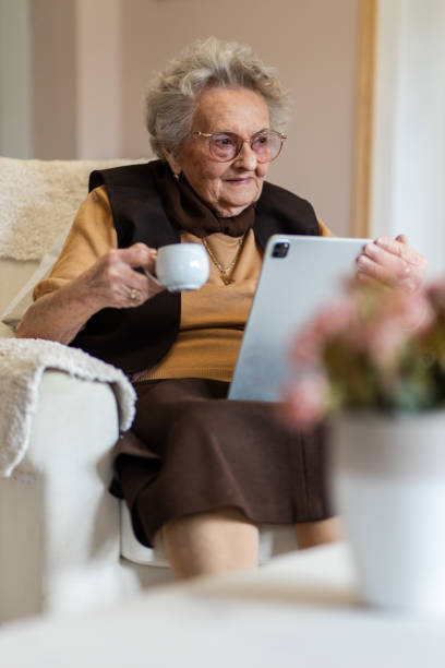 istock Grandma holding a tablet and a cup of tea 1395176824
